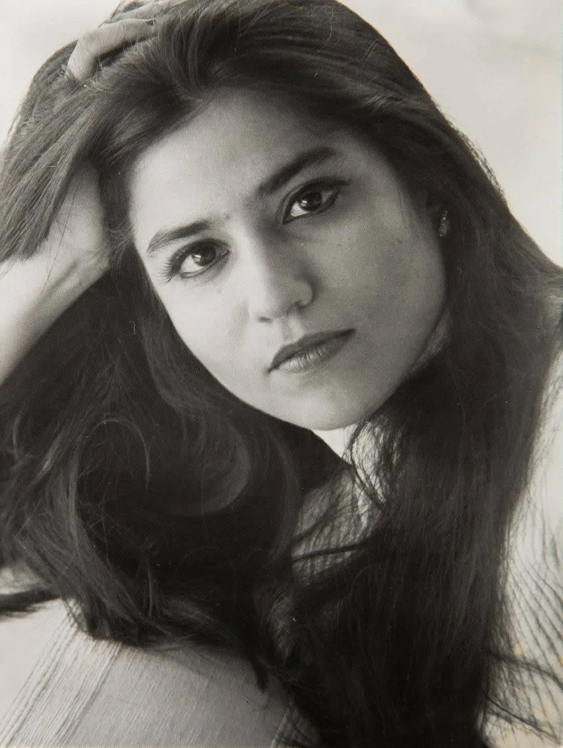 A woman with long hair is posing for the camera.